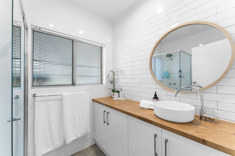 Clean, modern and functional, the bathroom features a walk-in shower and practical storage.