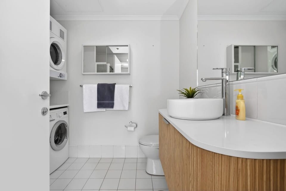 Bathroom with floating vanity & stacked washer/dryer