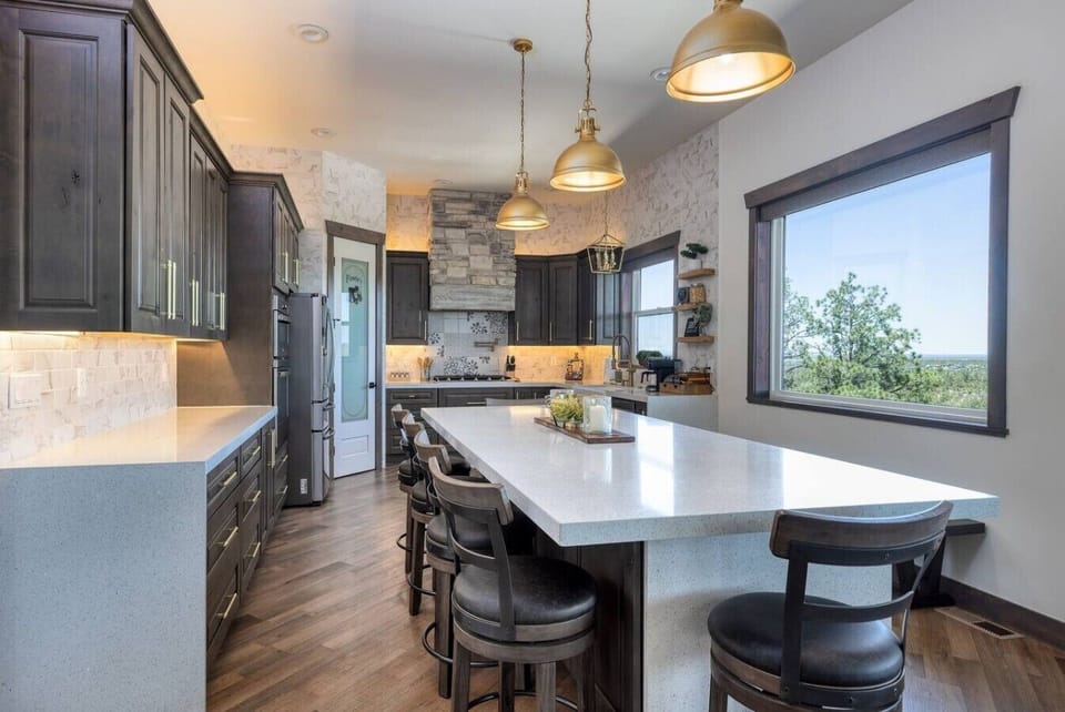Designed for entertaining, this chef’s kitchen features premium finishes, expansive countertops, and beautiful forest views.