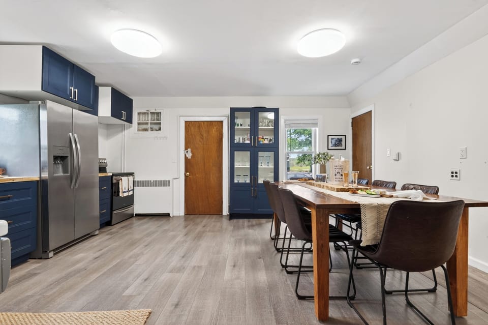 Open kitchen and dining area with blue cabinetry, stainless appliances, and plenty of room for group meals.
