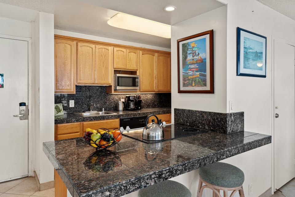 Kitchen pass-through with breakfast bar seating and granite counters.