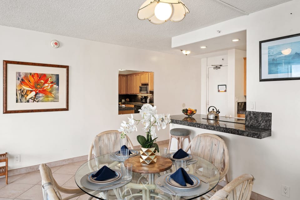 Dining space with seating for four next to a fully equipped kitchen.