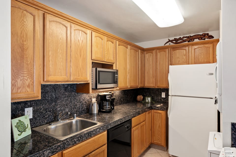 Fully equipped kitchen with granite counters and essential appliances.