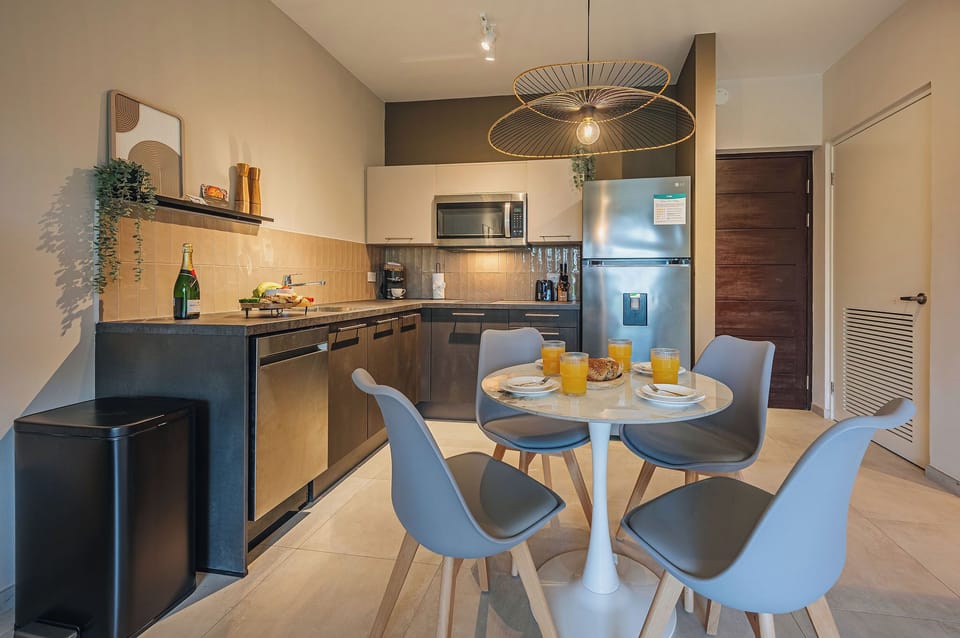 Modern dining seating and soft ambient lighting create a welcoming setting beside the contemporary kitchen layout.
