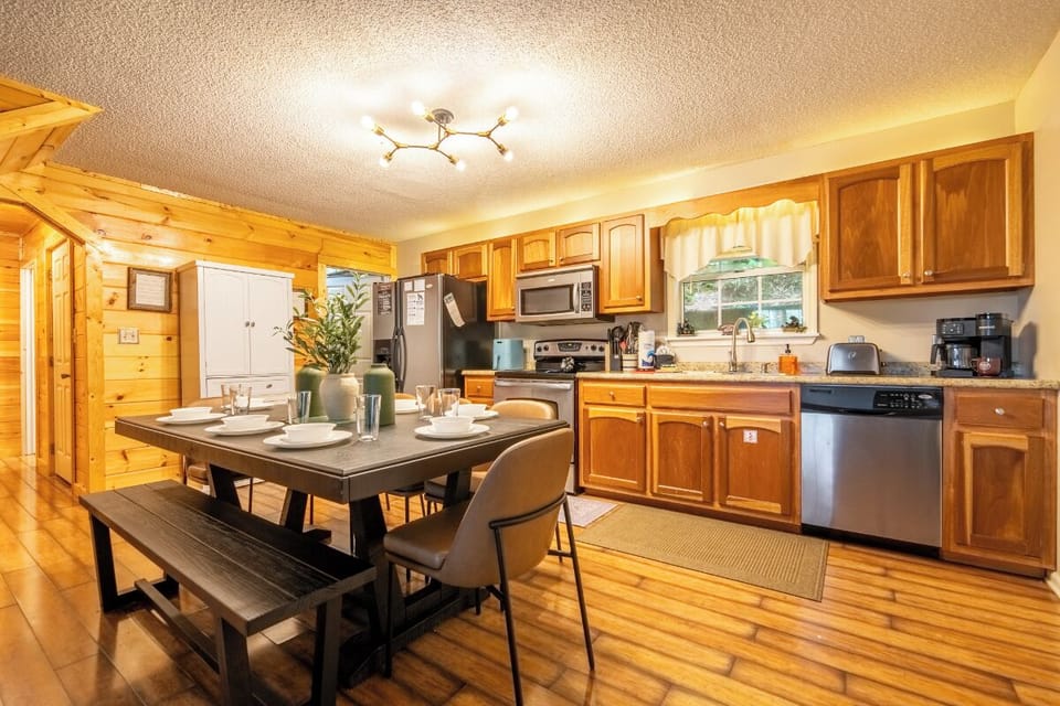 Step into your fully equipped kitchen and dining area, where warm wood tones create a cozy mountain retreat atmosphere perfect for preparing and sharing memorable meals together.