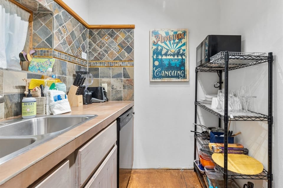 Quaint kitchen featuring a gas range, dishwasher, full-size refrigerator, and coffee maker.