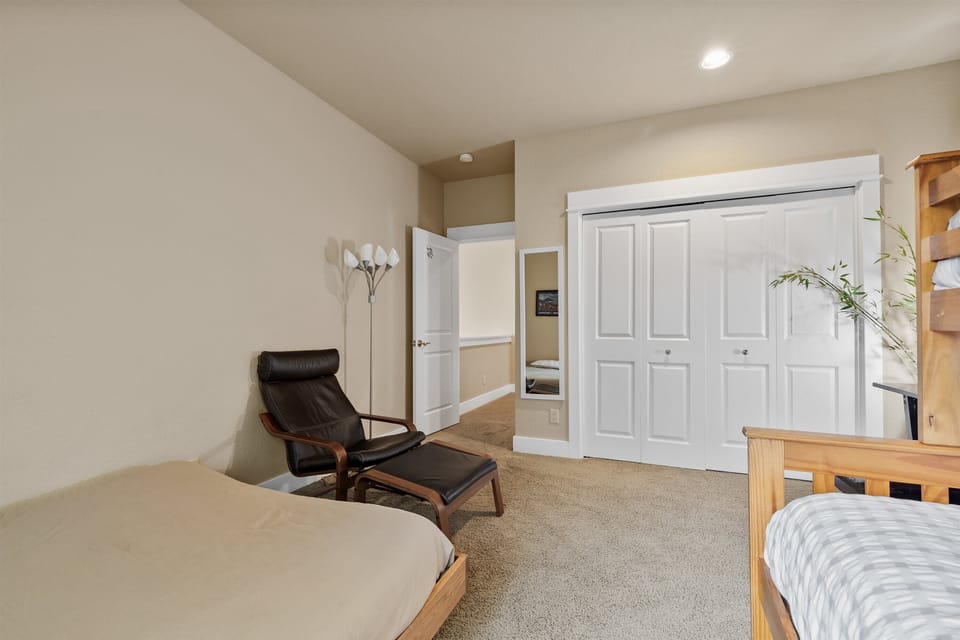 Bunk room with lounge chair and closet — perfect for kids.