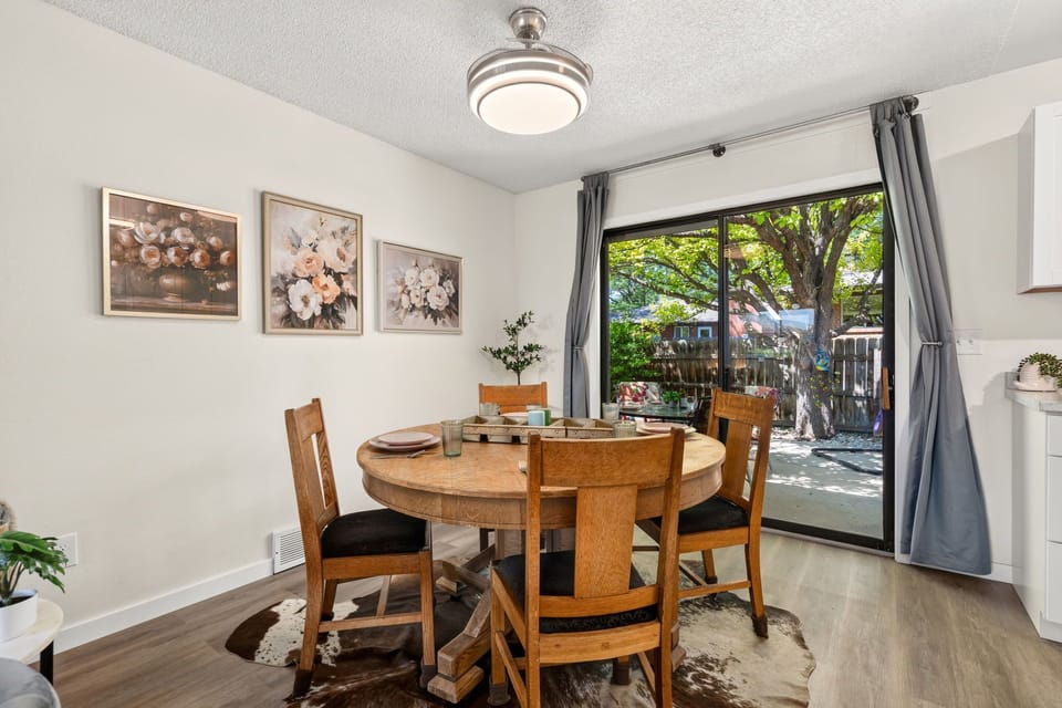 Picture yourself enjoying meals at this charming round dining table, bathed in natural light from the patio doors that frame your private outdoor retreat.