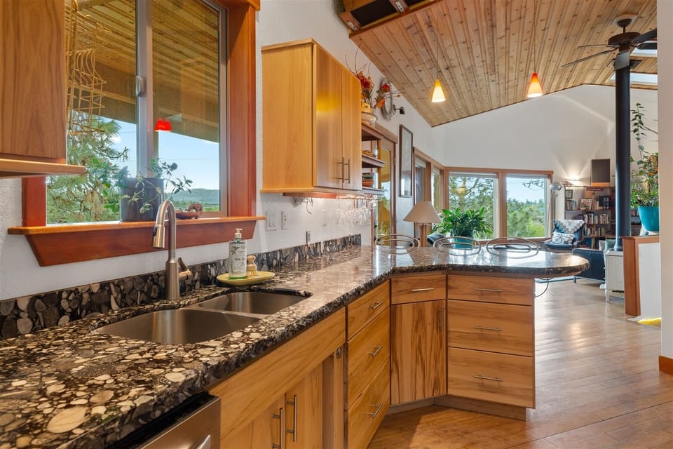Fully equipped kitchen with granite slab countertops.