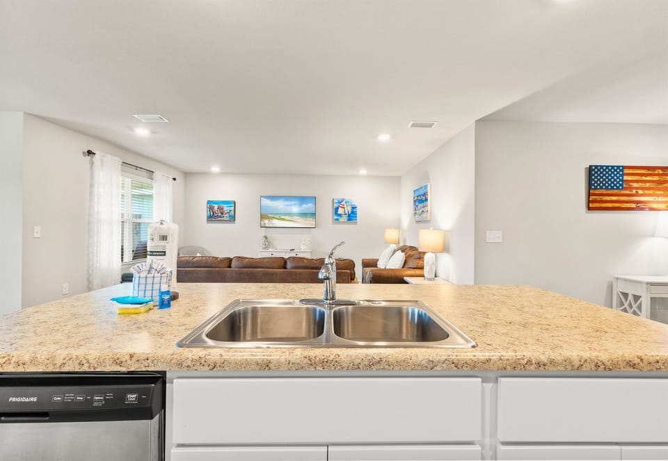 Spacious counter and double sink with living area views—perfect for cleanup while staying connected.