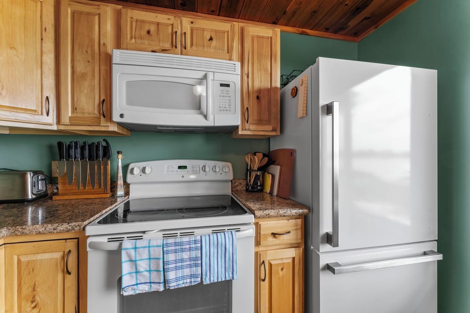 Your fully equipped kitchen features modern appliances, granite countertops, and warm wood cabinetry—everything you need to whip up a home-cooked meal or morning coffee during your stay.