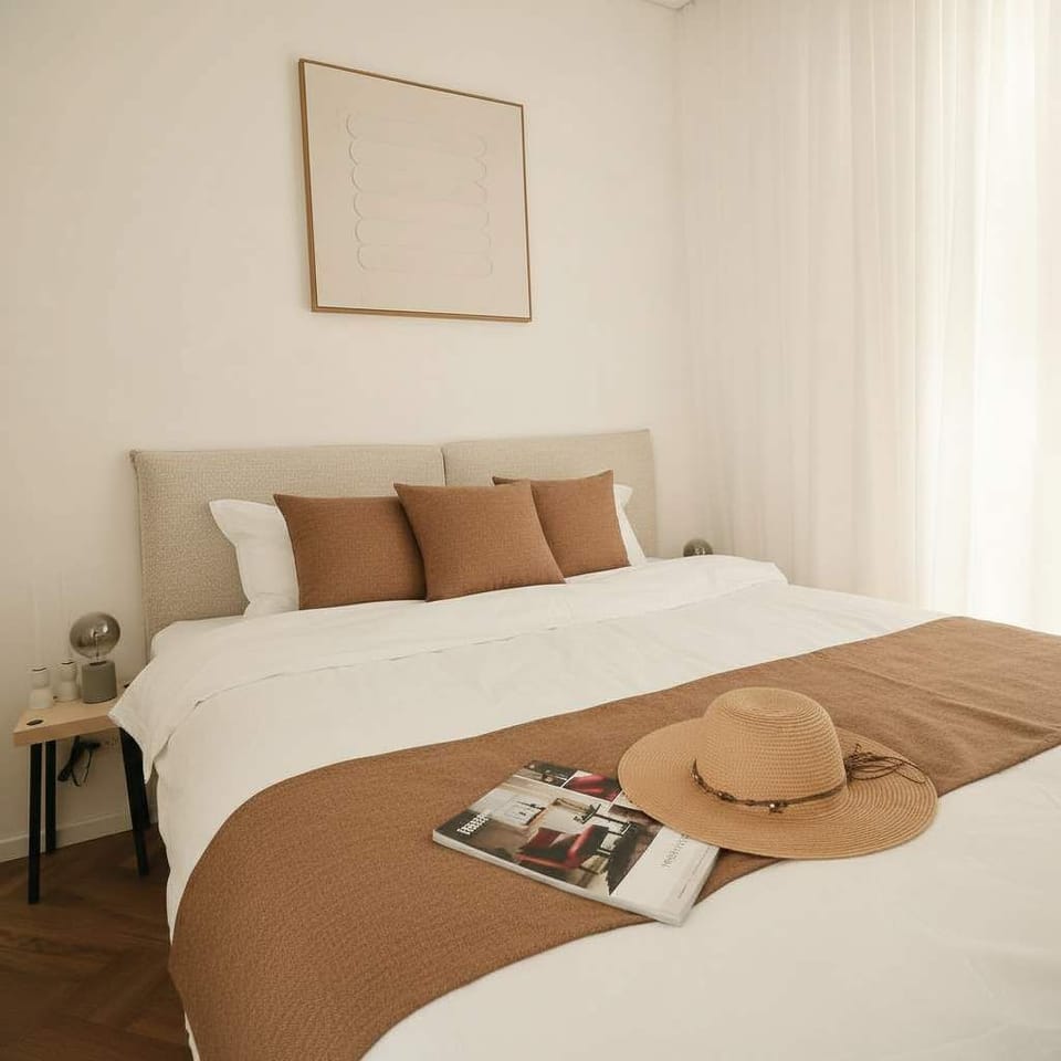 Bright minimalist bedroom framed by sheer curtains, creating peaceful mornings before exploring vibrant local streets.