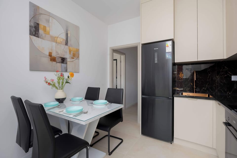 A dining area next to the kitchen with a small table and chairs. The space is bright and stylish.