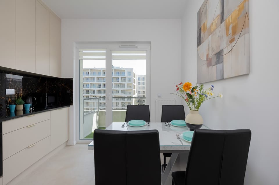 A modern kitchen with a dining table and chairs. The space is clean and functional.