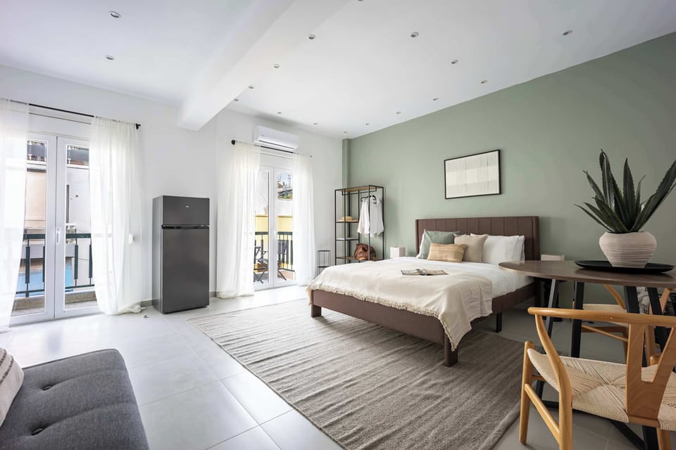 A bright corner of the studio where dining, lounging, and resting come together, all enhanced by the glow from two full-height balcony doors