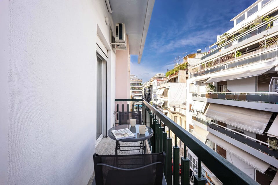 A narrow balcony with a small table setup, offering a clear street view and a quiet spot to enjoy fresh air.