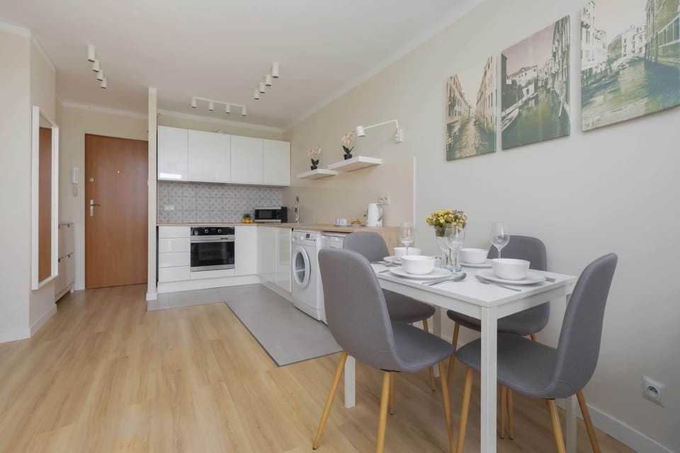 Bright living and dining area with comfortable furnishings, a dining table and a practical kitchenette, creating a convenient space for relaxing and enjoying meals.