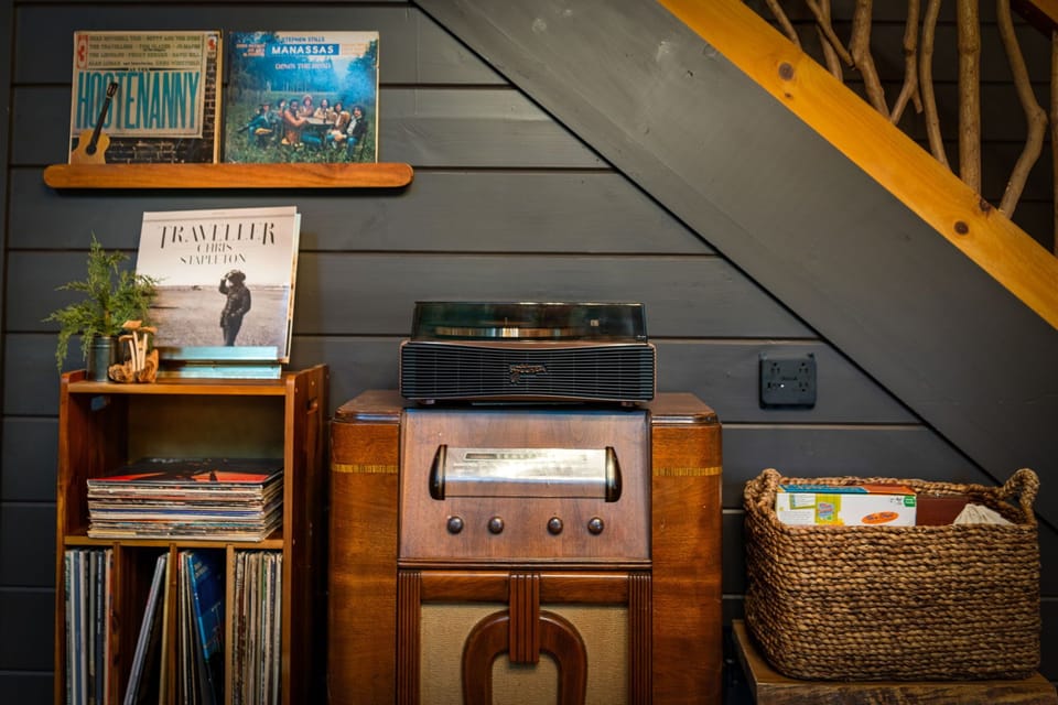 Vinyl spinning softly, books stacked, and nostalgic camp energy filling the room. This cozy corner was made for slowing down.