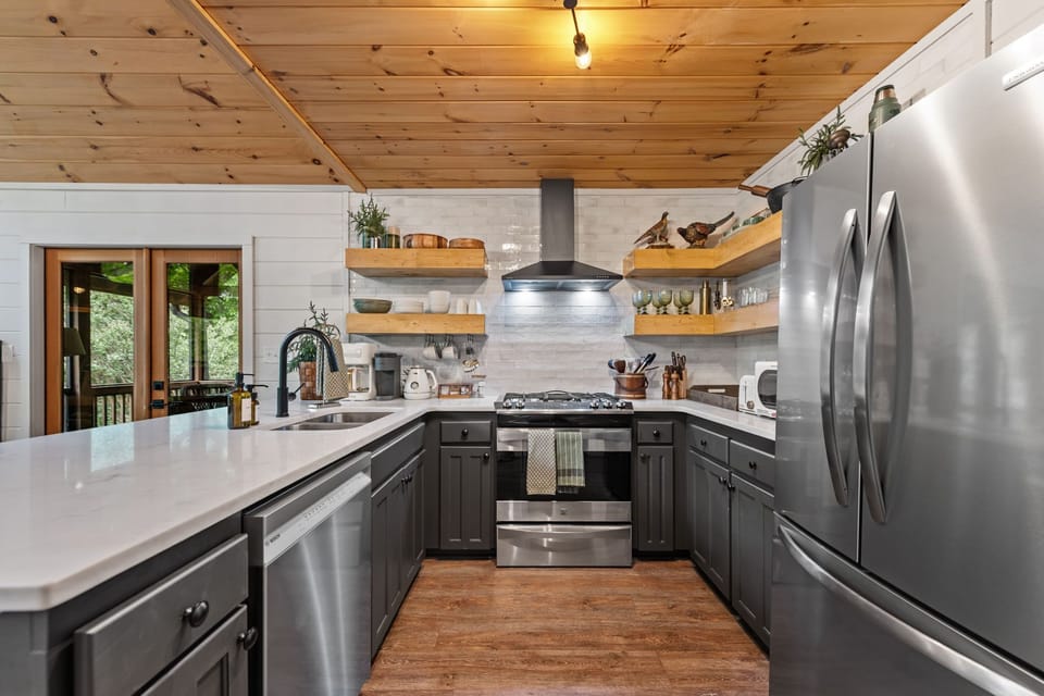 Gray cabinetry, lush plants, and playful décor details bring warmth, personality, and a nature-inspired elegance into the heart of the cabin.