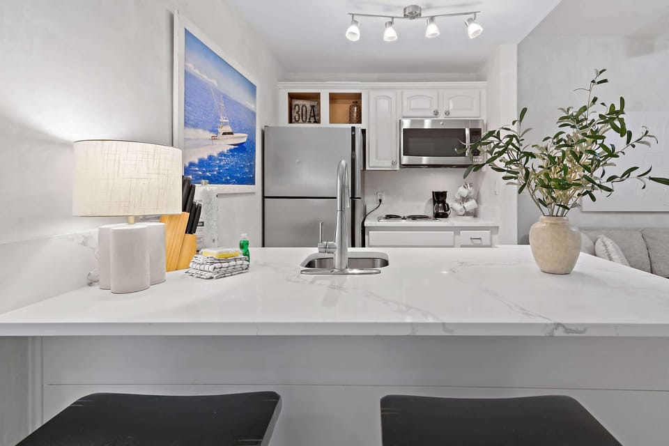Kitchen: Bar seating, stovetop, microwave, refrigerator, drip coffee maker, cookware & dinnerware