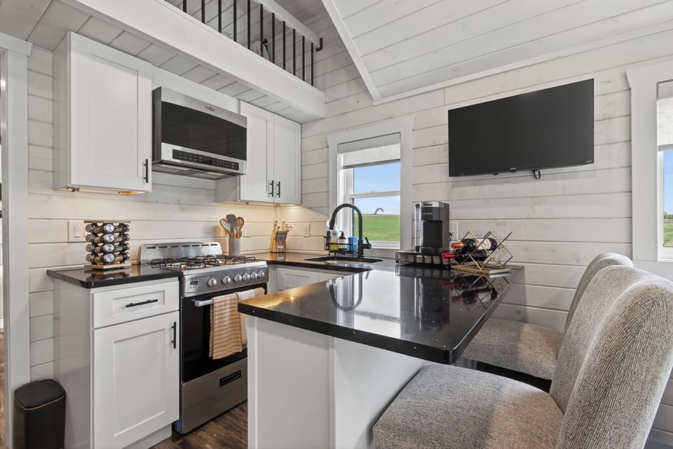Bright modern kitchen with island seating, coffee bar, and scenic views