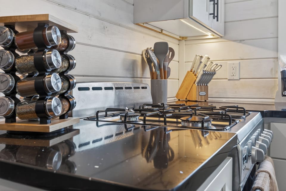 Well-stocked gas cooktop with modern finishes and farmhouse charm