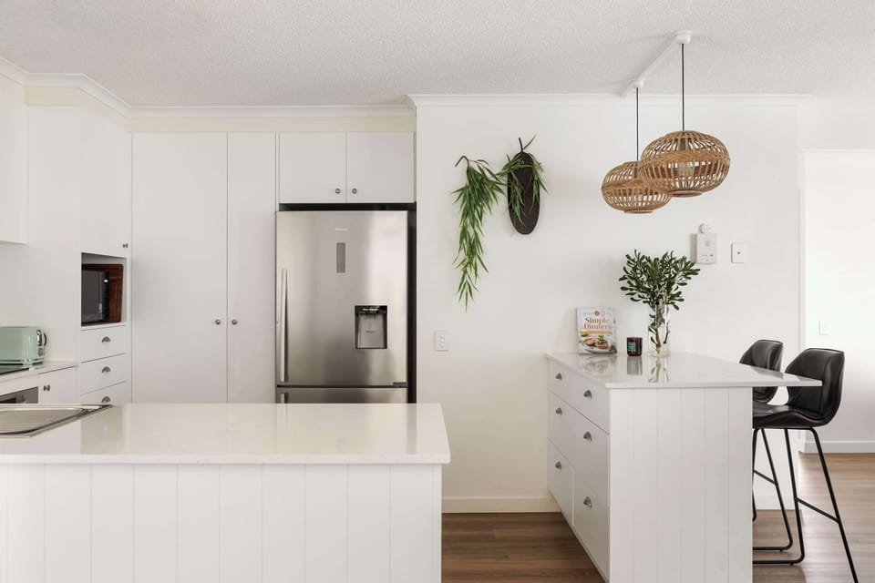 The fully equipped kitchen features quality appliances, generous bench space and a breakfast bar — perfect for easy meals or morning coffee.