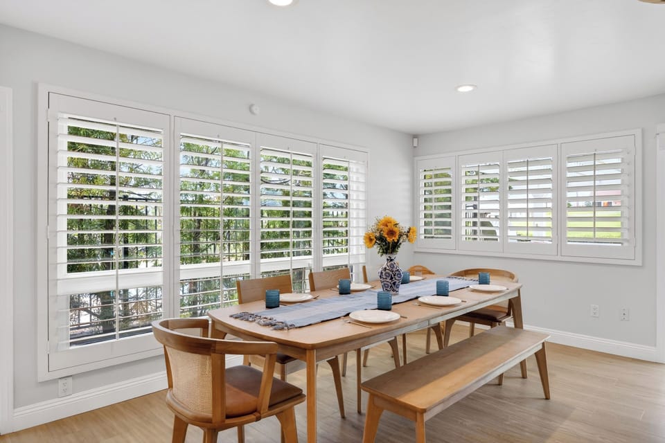 A formal dining space bordered by elegant plantation shutters, offering a sophisticated backdrop for dinner parties.