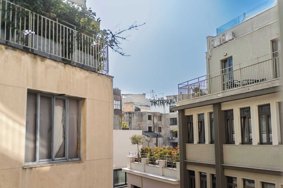 Sunlit window outlook reveals surrounding architecture and vibrant city energy, immersing you in local character.