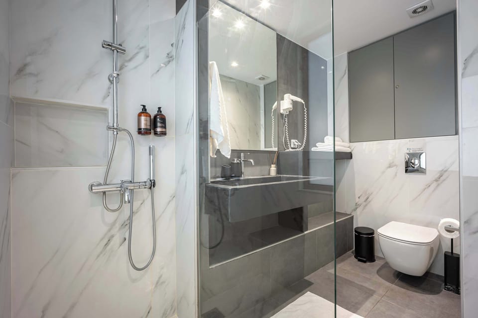 Luxury glass shower with marble accents elevates daily routines into refreshing, spa-inspired experiences.