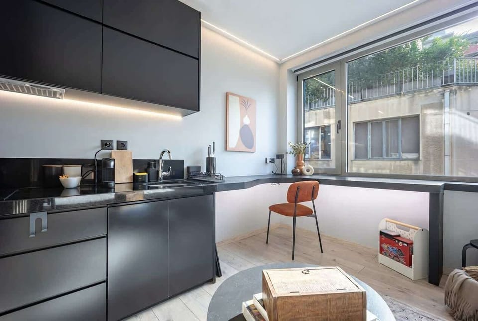 Sleek kitchenette beside expansive windows creates a delightful spot for morning coffee rituals.