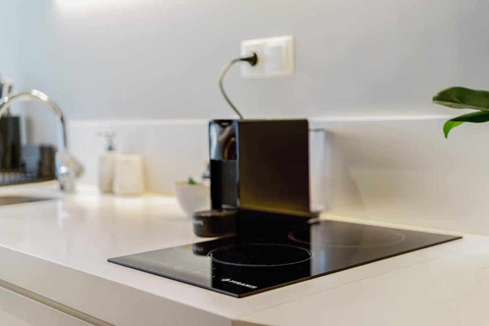 Start mornings with espresso from the sleek coffee machine beside a stylish modern kitchenette.