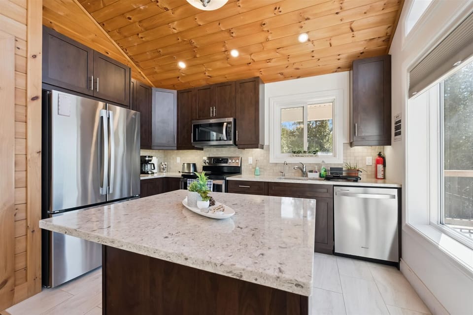 The fully equipped kitchen features modern appliances, ample counter space, and a central island for meal preparation.
