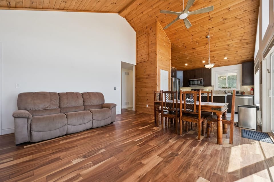 The bright, open-concept living and dining area features soaring cathedral ceilings and plenty of space for gathering together.