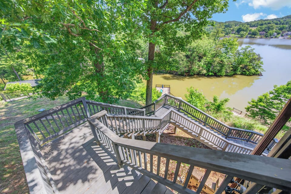 Multi-level stair access leading down to the lake and private dock, surrounded by wooded views and peaceful scenery.