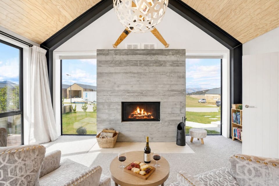 Warm up by the log-burning fireplace in this light-filled living space with beautiful landscape views
