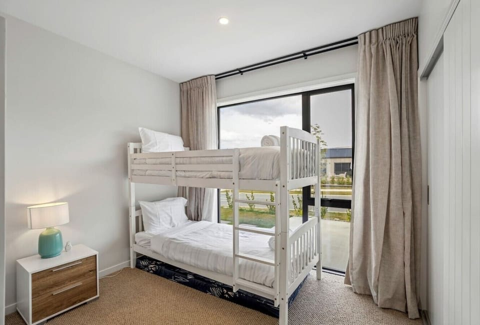Bunk room with quality bedding and natural light - sleeps extra guests in comfort