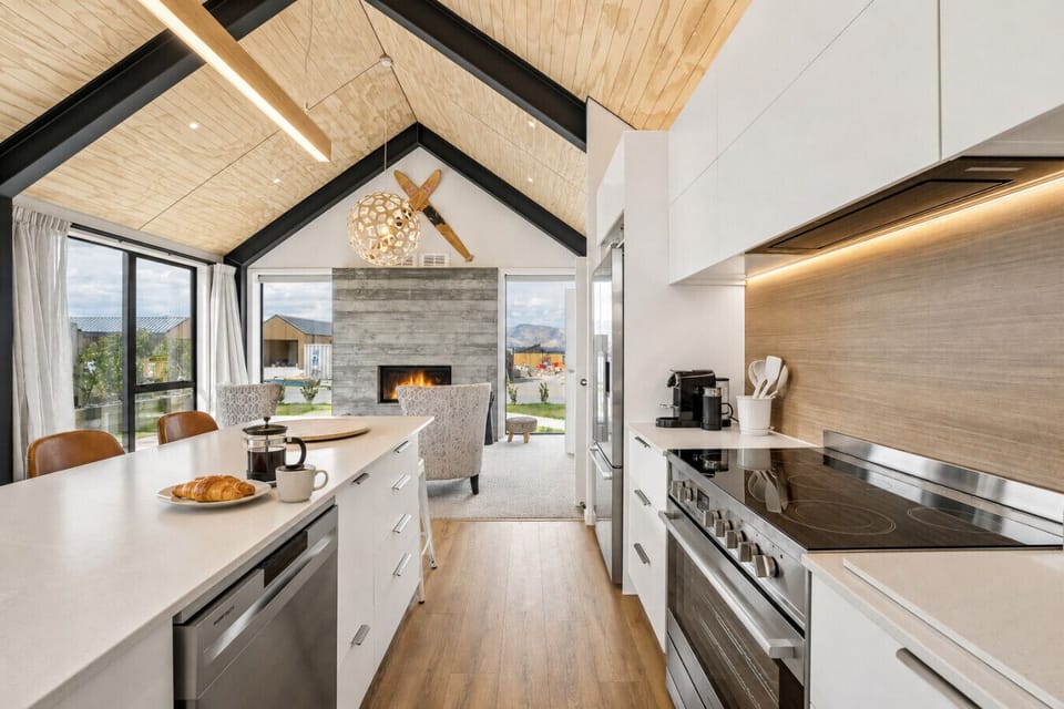 Open-plan dining area with a statement stone fireplace, wooden accents, and alpine views - perfect for gathering after a day of adventure