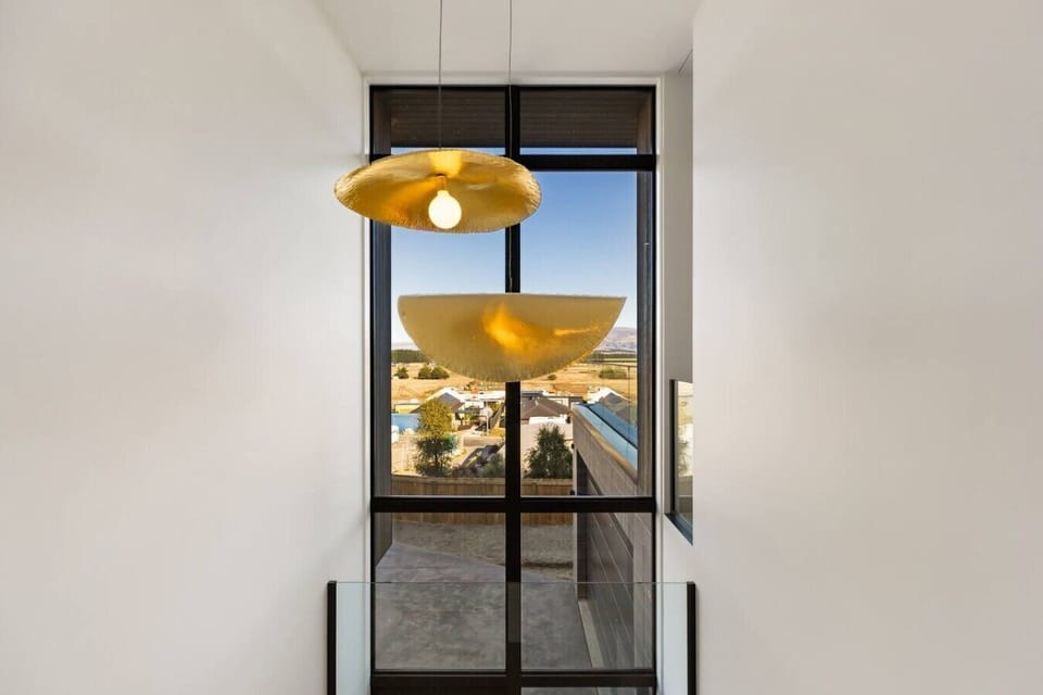 Watch your morning unfold through floor-to-ceiling windows while golden pendant lights cast a warm glow above