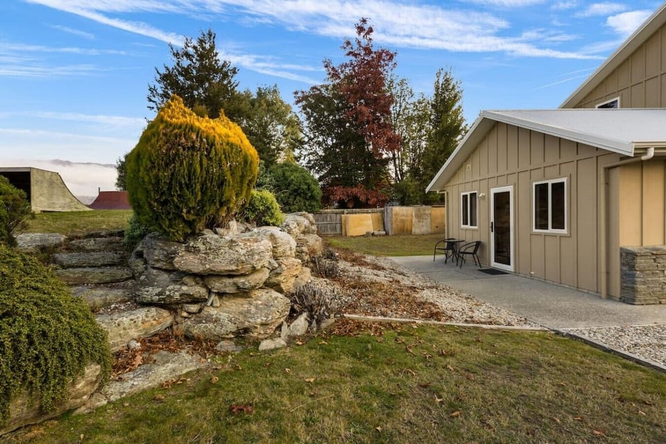 Spacious grounds with mature trees, rock garden feature, and peaceful outdoor areas to explore and relax in.