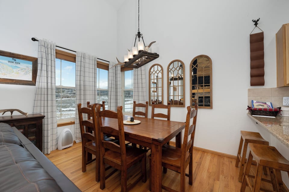 Gather around your rustic wooden dining table for memorable meals while enjoying stunning mountain views through large windows.