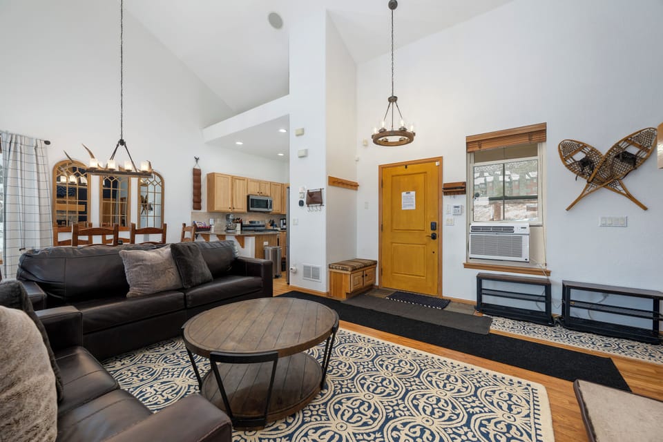 Sink into this cozy living space where rustic charm meets modern comfort, featuring a plush sofa and open layout perfect for relaxing.