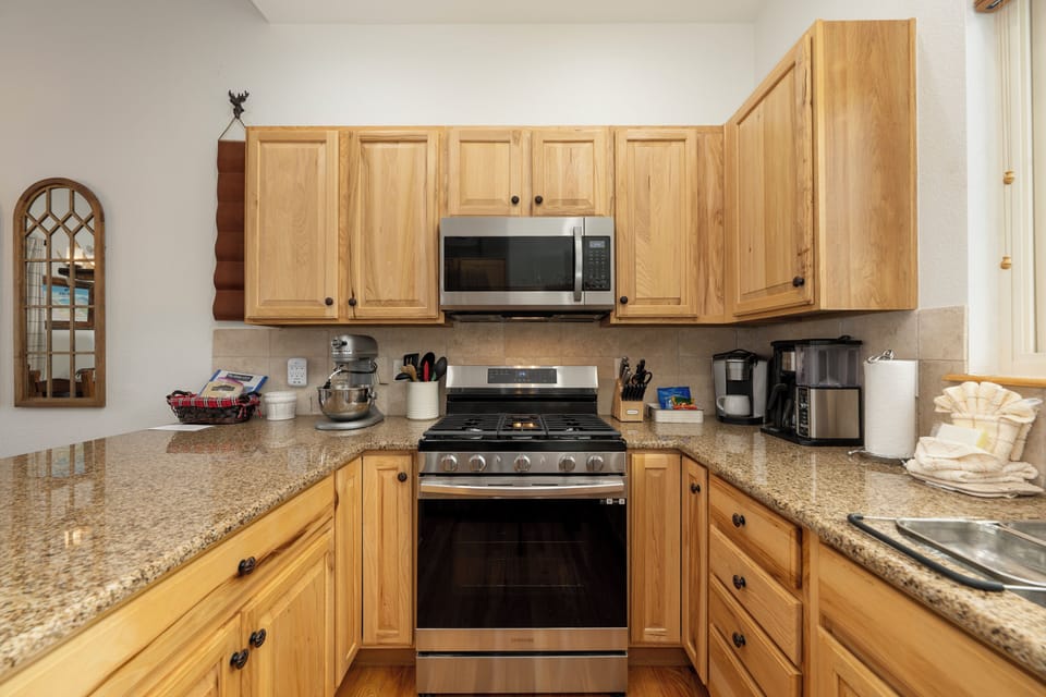 Your fully equipped kitchen features warm wood cabinets, granite counters, and everything you need to create memorable meals during your stay.