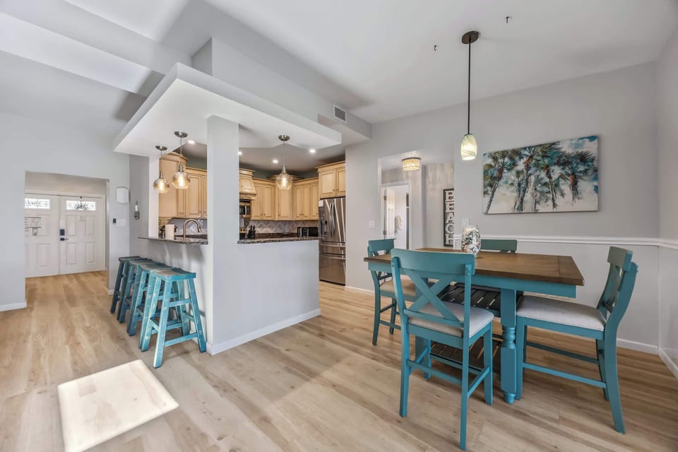 Open kitchen and dining area with coastal-inspired blue seating and natural light