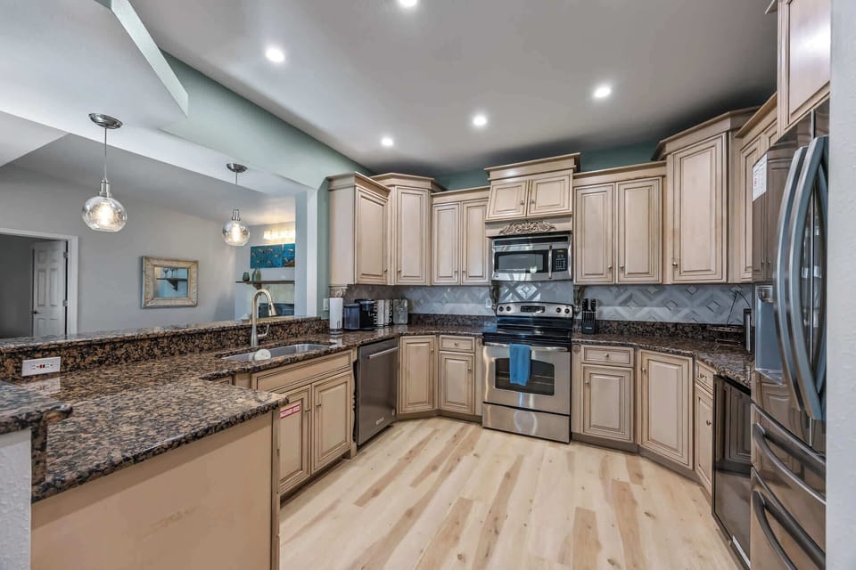Spacious kitchen with granite countertops and stainless steel appliances.