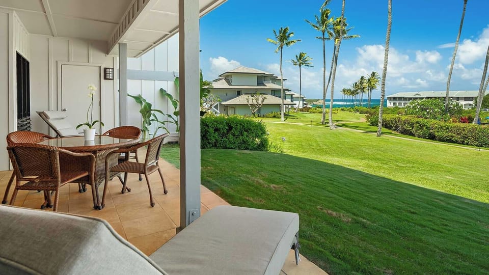Unwind on your private patio with ocean views, swaying palms, and manicured lawns stretching toward turquoise waters—your perfect tropical escape awaits.