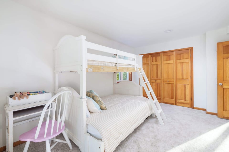 Mid Level Bunk Room: Fun and spacious bunk room featuring a twin-over-full bunk bed with a full trundle, TV, desk, deck access, and convenient access to the shared full hall bathroom