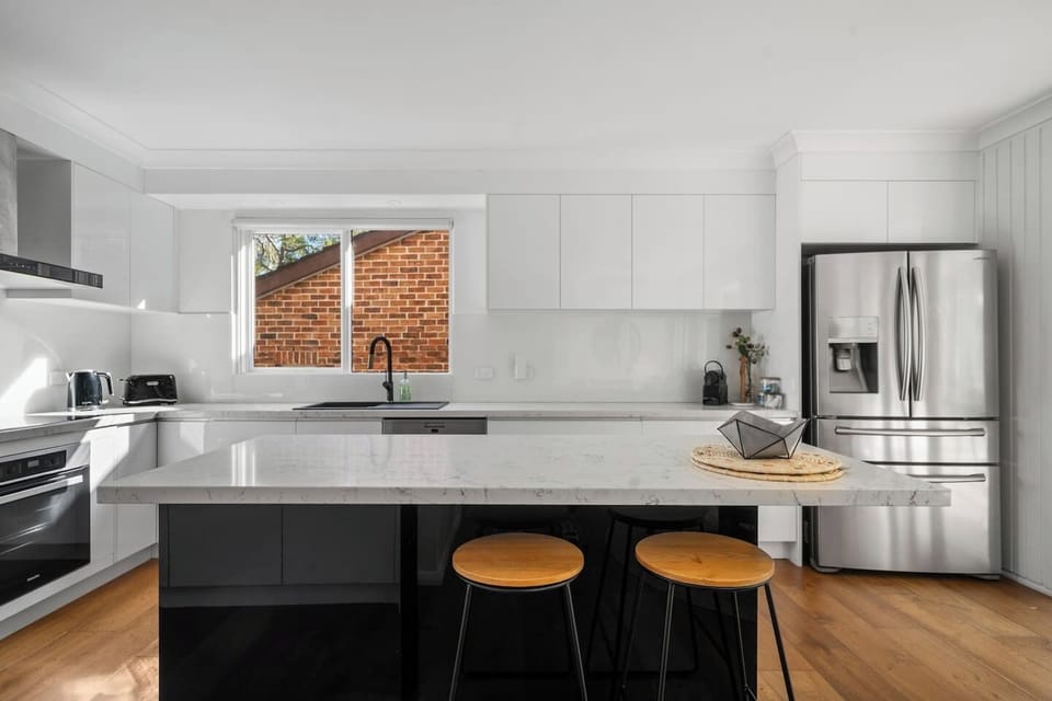 Gather around the sleek kitchen island with stools for casual breakfasts, evening wine, or easy conversation while meals are prepared nearby.