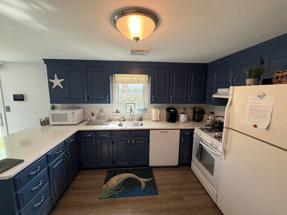 Your fully equipped kitchen features coastal-inspired navy cabinetry and all the essentials for preparing home-cooked meals during your stay.