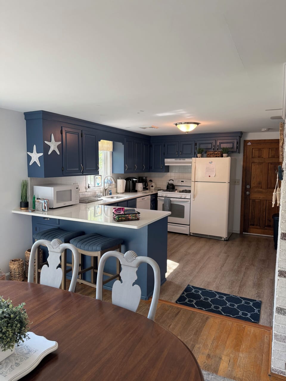 Your bright and welcoming kitchen features coastal-themed cabinetry, modern appliances, and a cozy dining nook—perfect for preparing meals and sharing stories over coffee each morning.